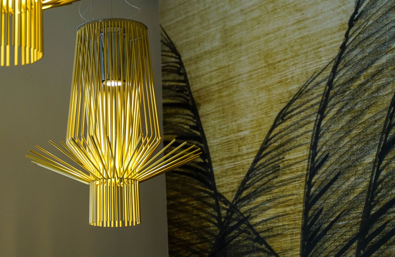 Elegant yellow bamboo chandelier illuminating a creative interior space with artistic design elements.